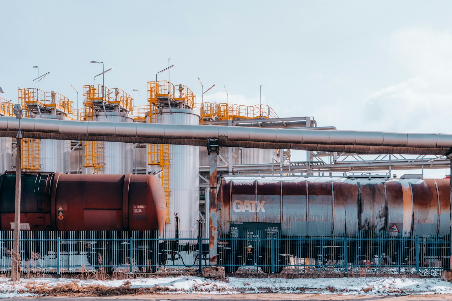 Large industrial storage tanks and pipelines in a snowy outdoor setting.